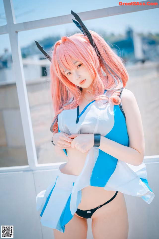 A woman with pink hair wearing a blue and white outfit.