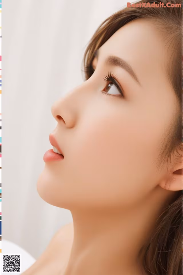 A woman with long brown hair is looking up at the sky.