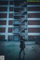 A woman standing in front of a tall building.