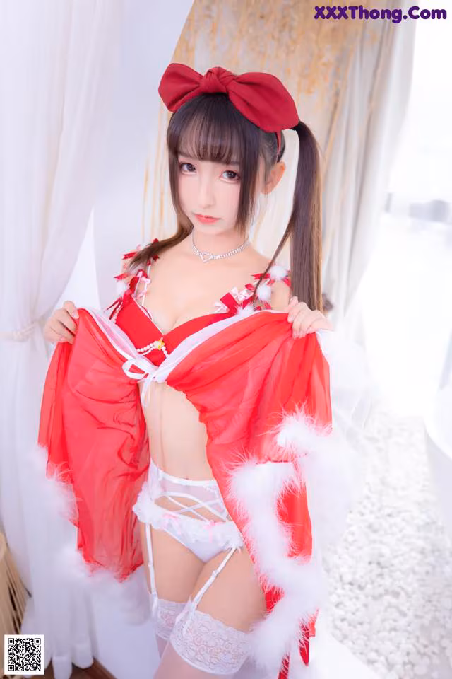 A woman in a red and white lingerie posing for the camera.