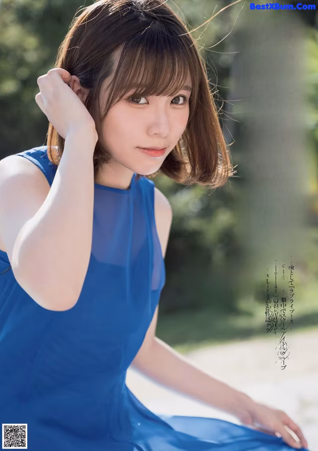 A woman in a blue dress posing for a magazine cover.