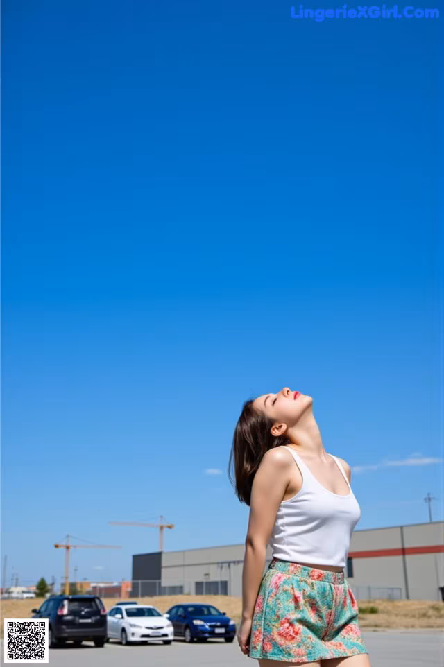 A woman standing in the middle of a parking lot.