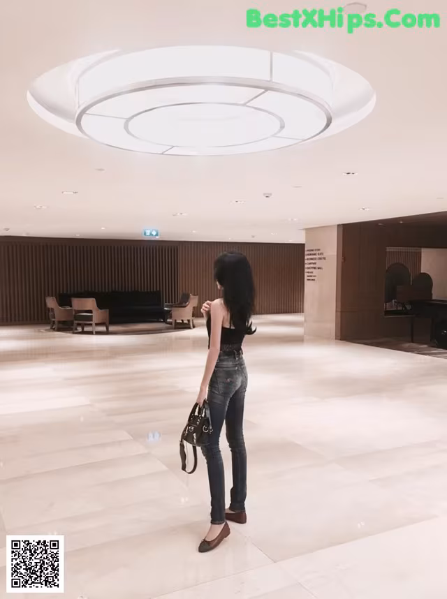 A woman standing in the middle of a large lobby.