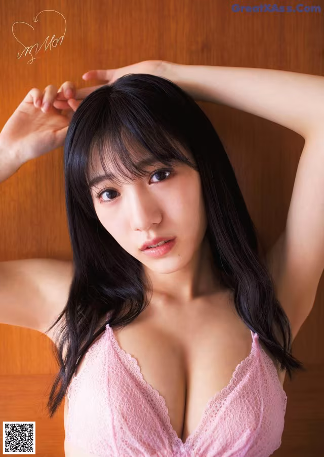 A woman in a pink bra posing for a picture.